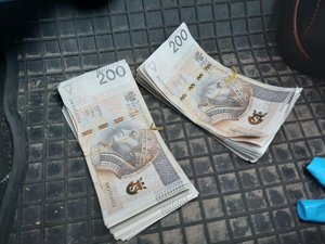 dwa pliki pieniędzy o nominale 200 złotych leżą na wycieraczce samochodowej