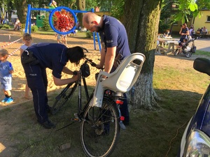 policjantka graweruje rower mężczyzny, który stoi obok