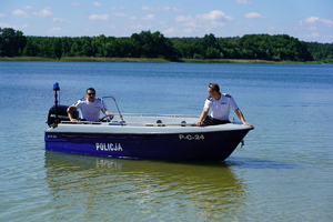 Jezioro w Borównie. Policjanci płyną łodzią motorową.