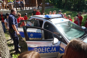 Dzieci oglądają radiowóz policyjny.