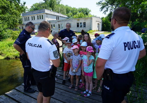 policjanci rozmawiają ze zgromadzonymi dziećmi