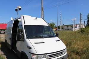 pojazd Mobilne Centrum Monitoringu stoi przy drodze i obserwuje kamerami przejazd kolejowy