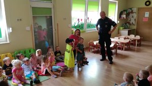 Policjant podczas pogadanki z dziećmi w sali placówki.