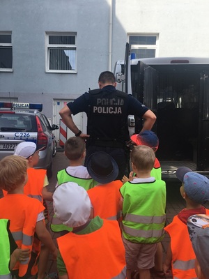 Policjant prezentuje dzieciom swoje umundurowanie.