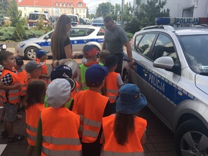 Dzieci wraz z policjantami przy radiowozach.