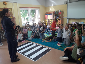 Policjantka podczas spotkania z dziećmi w sali lekcyjnej.