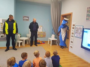 Polfinek wraz z policjantami podczas zajęć z dziećmi w sali przedszkola.