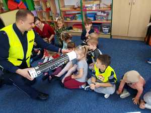 policjant prezentuje dzieciom magiczną tubę