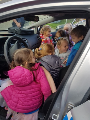 Dzieci oglądają radiowóz od środka.