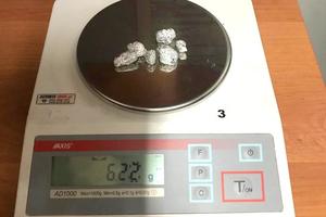 8 zawiniątek z folii aluminiowej z zawartością MDMA podczas ważenia na wadze elektronicznej
