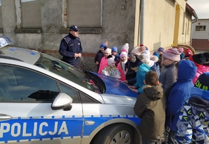 Policjant i dzieci przy radiowozie.