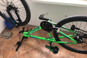 zabezpieczony odwrócony zielony rower leży na podłodze