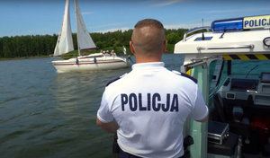 policjant podczas służby na wodzie policyjną łodzią motorową.