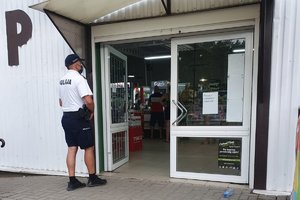 policjant stoi przed sklepem