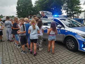 Dzieci oglądają policyjny radiowóz.