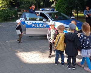 policjant pokazuje dzieciom policyjny radiowóz