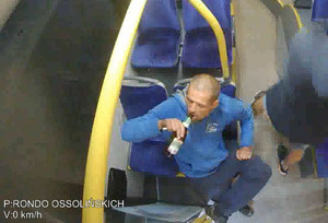 Mężczyzna siedzi w autobusie i pije piwo.