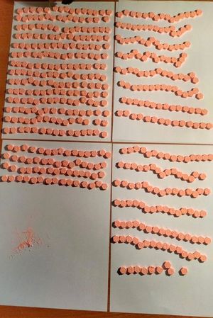 zabezpieczone pomarańczowe tabletki leżą rozłożone na kartce