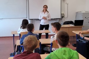 kobieta profilaktyk z Komisariatu Policji Bydgoszcz-Śródmieście rozmawia z dziećmi w klasie