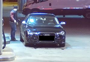 Audi stoi na stacji paliw przy dystrybutorach. Obok niego mężczyzna.