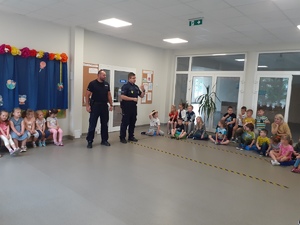 Policjanci i dzieci podczas zajęć w sali przedszkola.